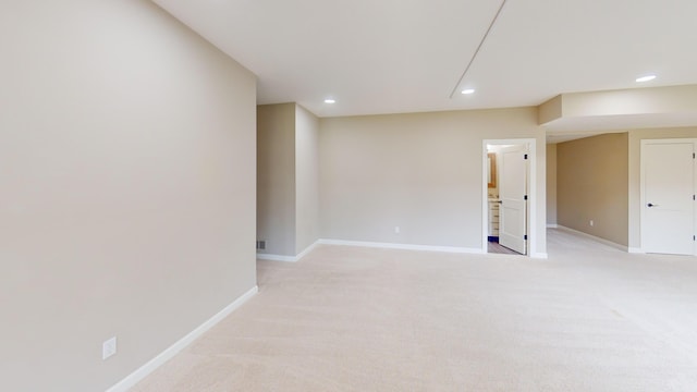 spare room featuring light carpet, baseboards, and recessed lighting