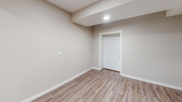 spare room with baseboards and wood finished floors