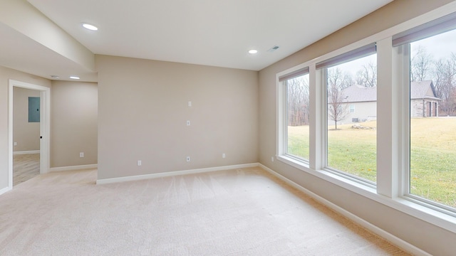 empty room featuring recessed lighting, light colored carpet, visible vents, baseboards, and electric panel