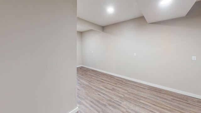 basement with light wood-style flooring and baseboards