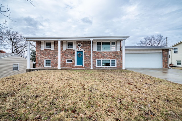 raised ranch with brick siding, driveway, a front lawn, and a garage