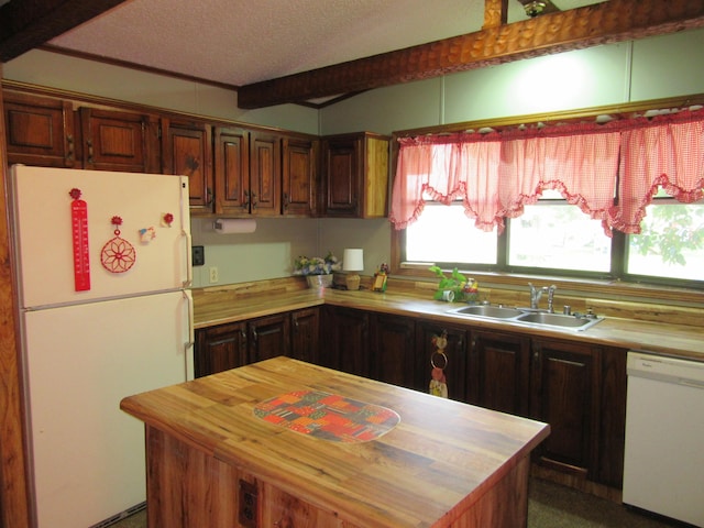 kitchen featuring white appliances, butcher block counters, a kitchen island, a textured ceiling, and a sink