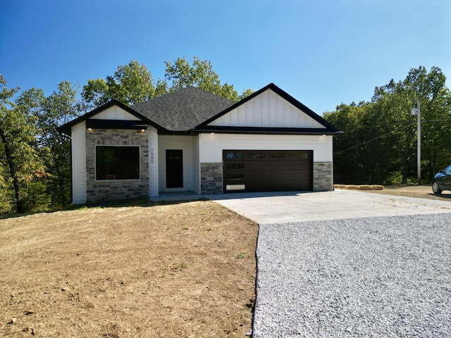 modern inspired farmhouse featuring an attached garage, driveway, stone siding, roof with shingles, and board and batten siding