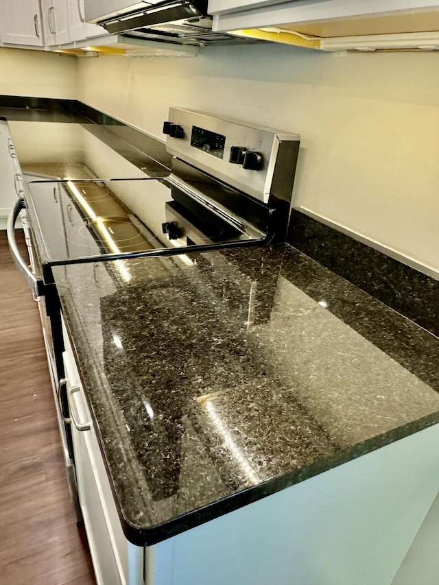 kitchen featuring dark wood-style floors, white cabinetry, and dark stone countertops