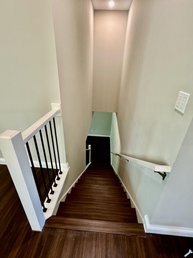 stairway with baseboards and wood finished floors