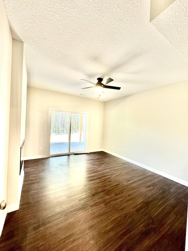 unfurnished room with ceiling fan, dark wood-style flooring, a textured ceiling, and baseboards