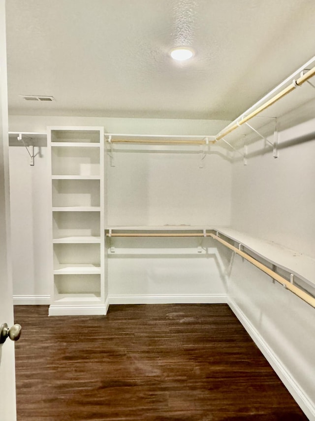 walk in closet with dark wood-type flooring and visible vents