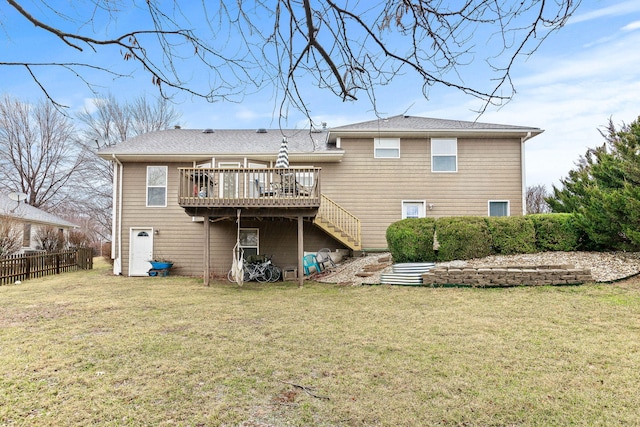 back of property featuring a lawn, fence, a wooden deck, and stairs