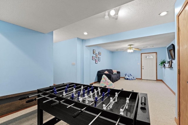 rec room featuring carpet, a textured ceiling, baseboards, and a ceiling fan