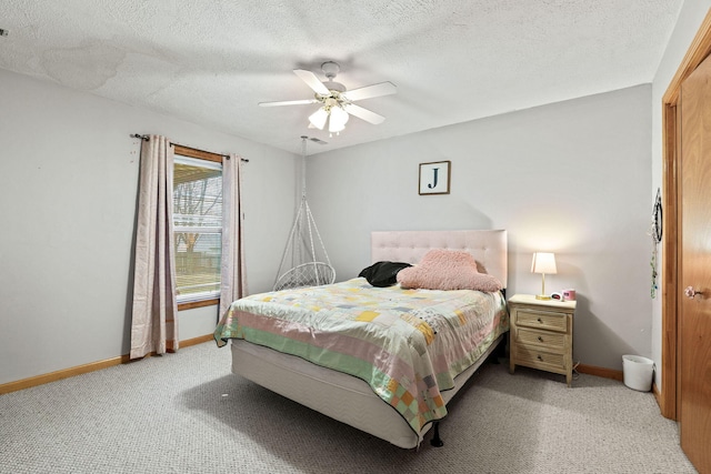 bedroom with light colored carpet, ceiling fan, a textured ceiling, and baseboards