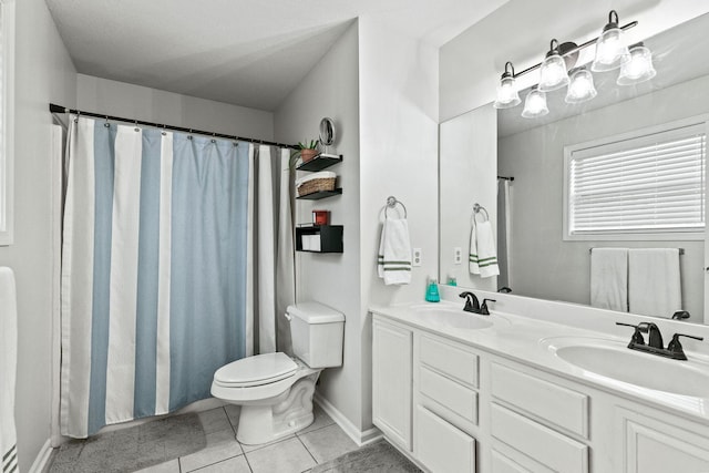 full bath featuring double vanity, a sink, toilet, and tile patterned floors