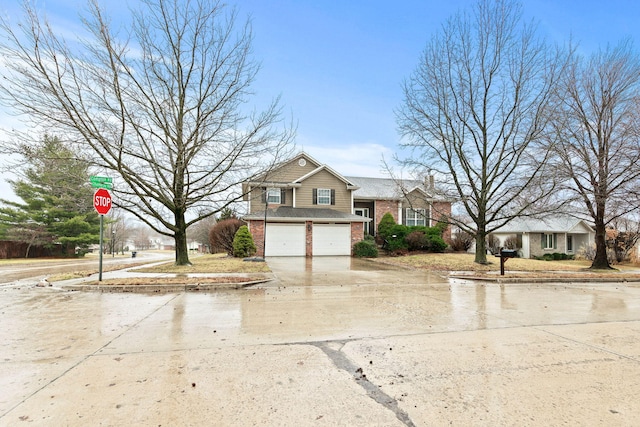 view of front of property with a garage, driveway, and brick siding