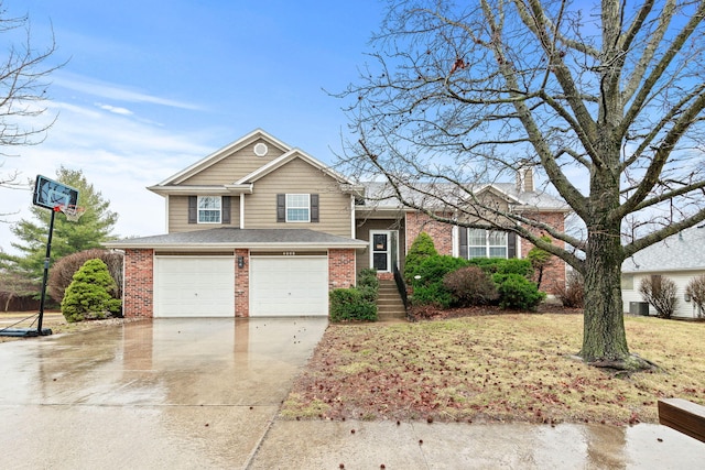 split level home with driveway, a garage, a chimney, and brick siding