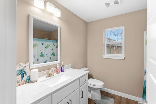 full bath featuring vanity, wood finished floors, visible vents, baseboards, and toilet