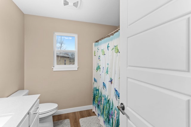 full bath featuring toilet, wood finished floors, a shower with shower curtain, baseboards, and vanity