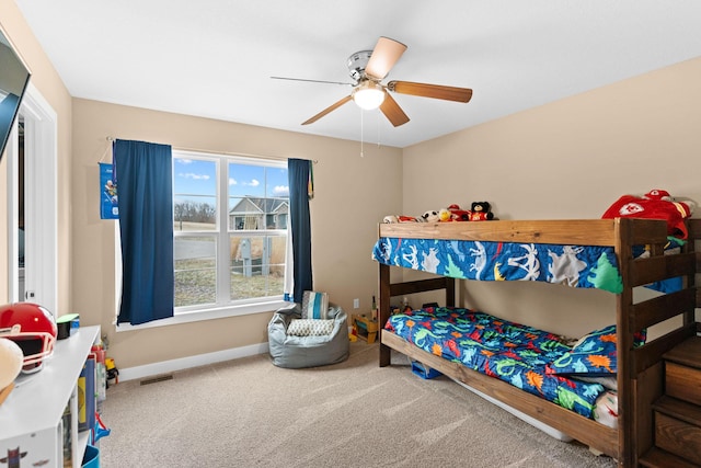 carpeted bedroom with a ceiling fan, baseboards, and visible vents