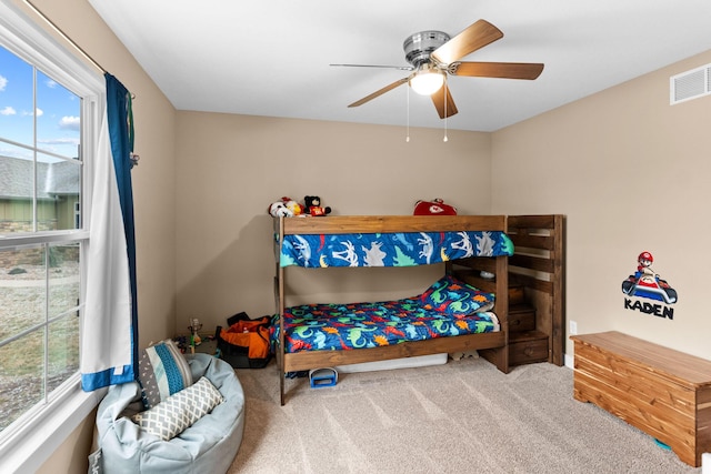 bedroom with visible vents, multiple windows, ceiling fan, and carpet floors