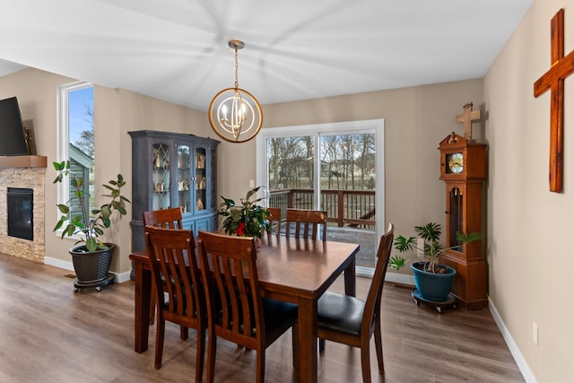 dining area featuring wood finished floors, plenty of natural light, and a fireplace