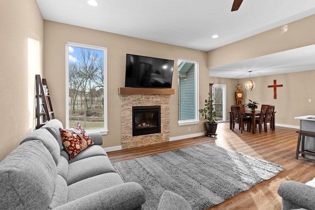 living room featuring recessed lighting, a fireplace, baseboards, and wood finished floors