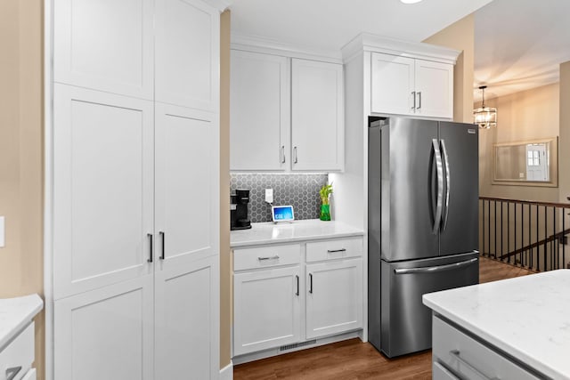 kitchen with visible vents, backsplash, freestanding refrigerator, white cabinets, and dark wood-style flooring