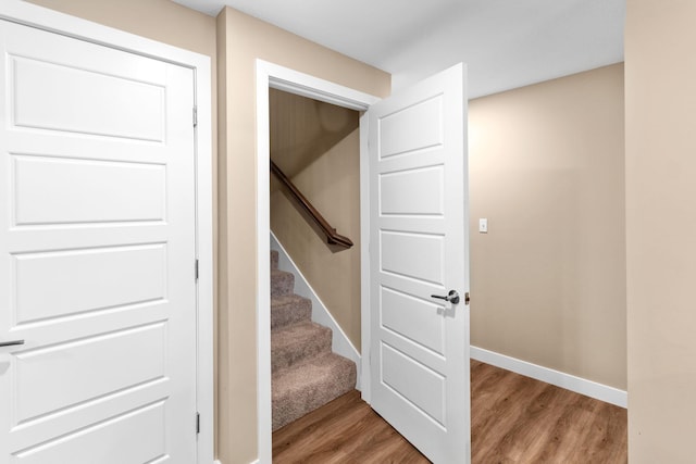 staircase featuring wood finished floors and baseboards