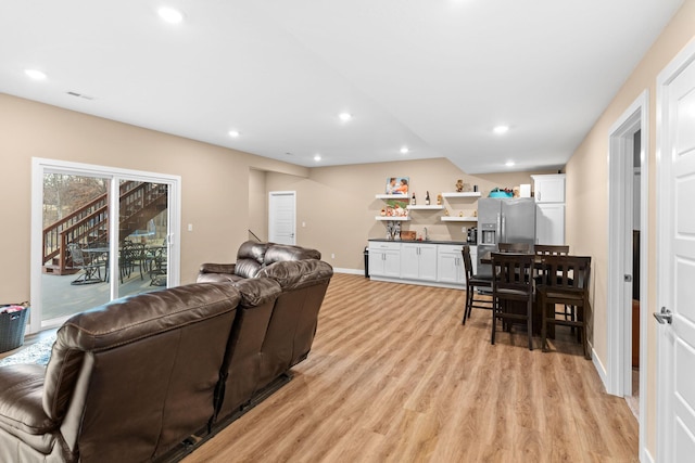 living room with recessed lighting, visible vents, baseboards, and light wood-style floors