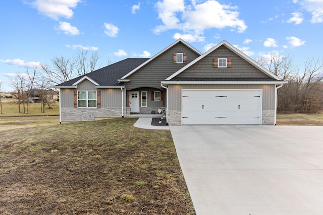 craftsman-style house with a shingled roof, concrete driveway, a front yard, stone siding, and an attached garage