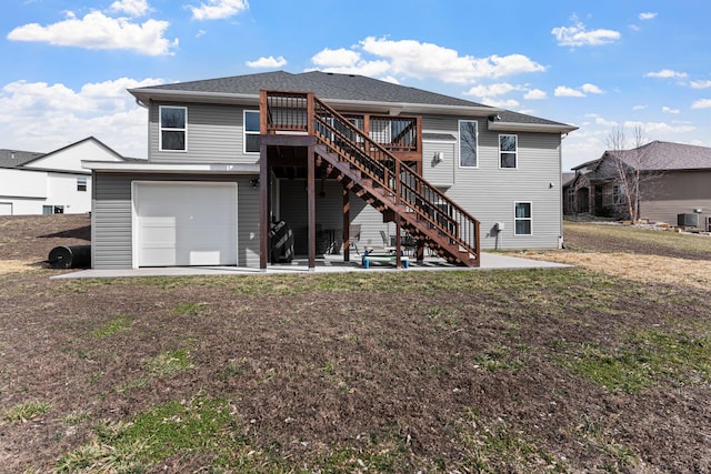 rear view of property featuring driveway, a patio, central AC, stairway, and an attached garage