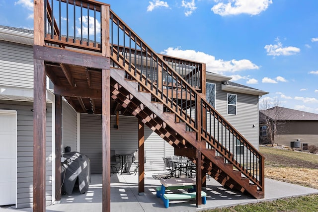 exterior space with stairway, outdoor dining area, a patio area, and central AC