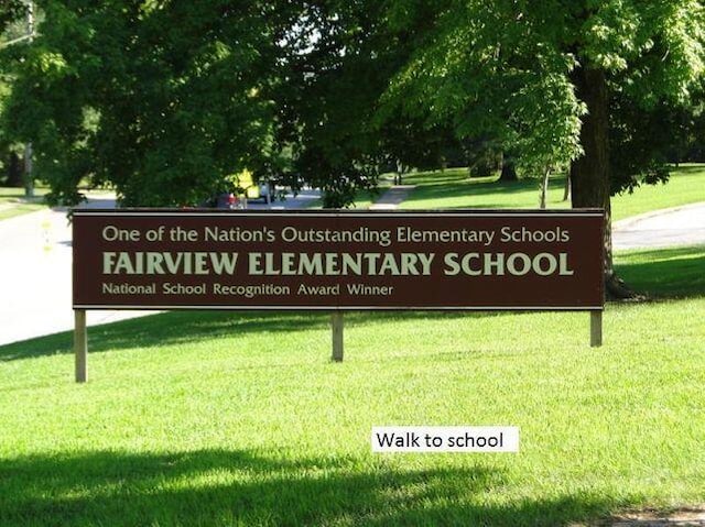 community / neighborhood sign featuring a yard