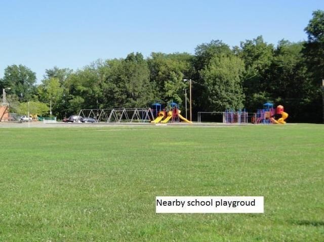 view of property's community with playground community and a yard