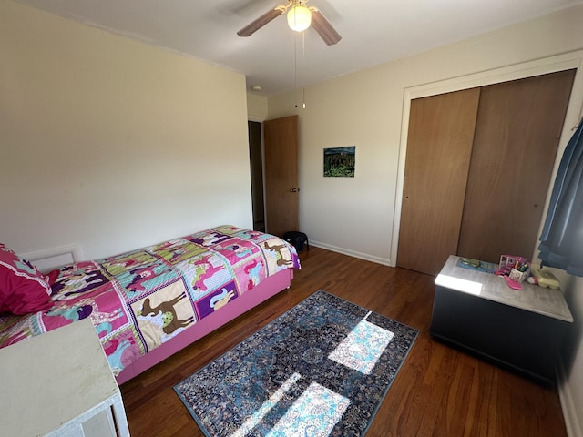 bedroom featuring a ceiling fan, wood finished floors, a closet, and baseboards