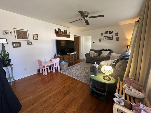 living area with wood finished floors, baseboards, and ceiling fan