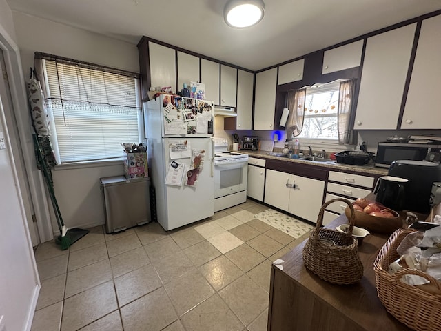 kitchen with white appliances, light tile patterned floors, a sink, white cabinets, and under cabinet range hood