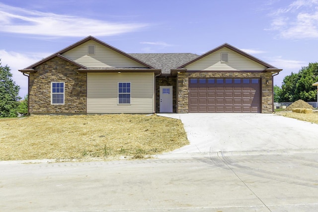 single story home with a garage, stone siding, and driveway