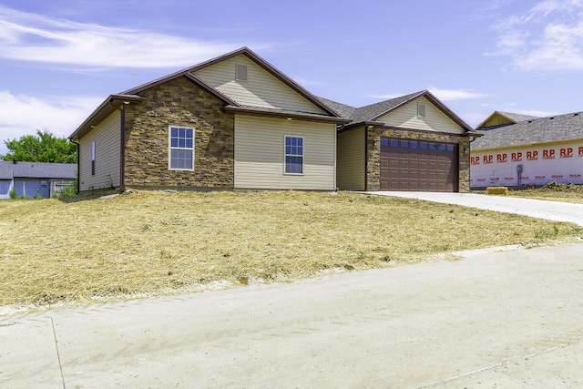 single story home featuring a garage, stone siding, and driveway