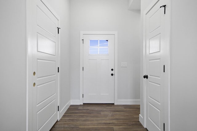 foyer with dark wood-type flooring and baseboards