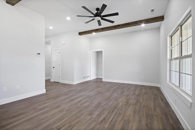 empty room with baseboards, visible vents, a ceiling fan, dark wood-style floors, and beamed ceiling