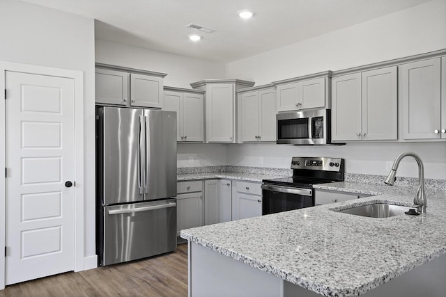 kitchen featuring stainless steel appliances, a sink, and gray cabinetry