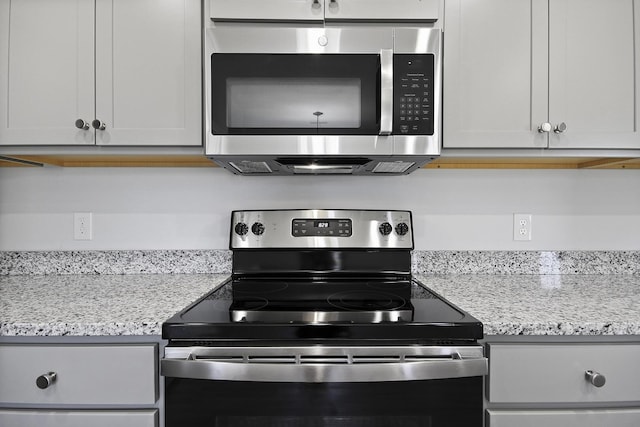 kitchen featuring stainless steel appliances and light stone countertops