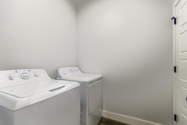 washroom featuring laundry area, dark wood-style floors, baseboards, and washer and clothes dryer