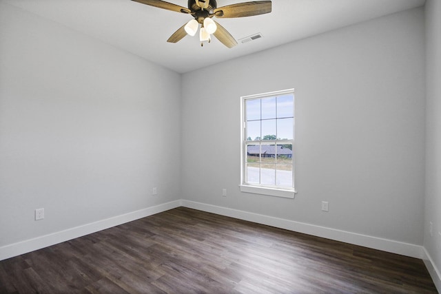 empty room featuring a ceiling fan, dark wood finished floors, visible vents, and baseboards