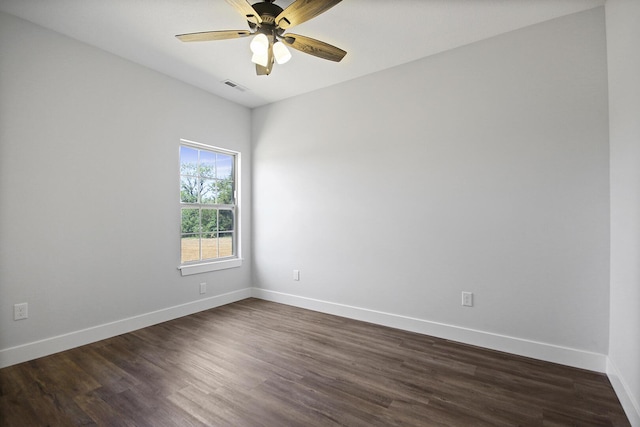 unfurnished room with dark wood-style floors, visible vents, ceiling fan, and baseboards