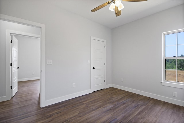 unfurnished bedroom with ceiling fan, dark wood-type flooring, and baseboards