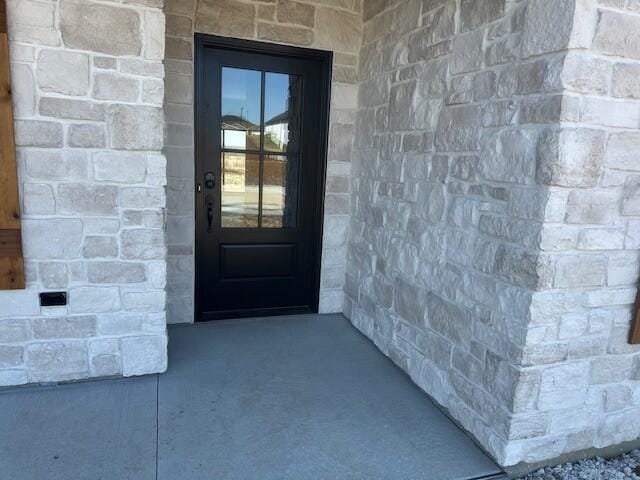 property entrance with stone siding