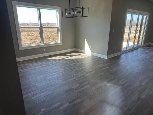 unfurnished dining area with baseboards, dark wood finished floors, and a healthy amount of sunlight