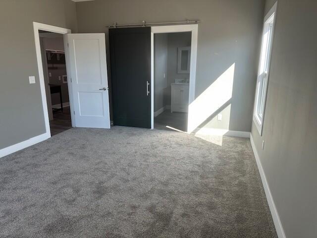 unfurnished bedroom with carpet floors and baseboards