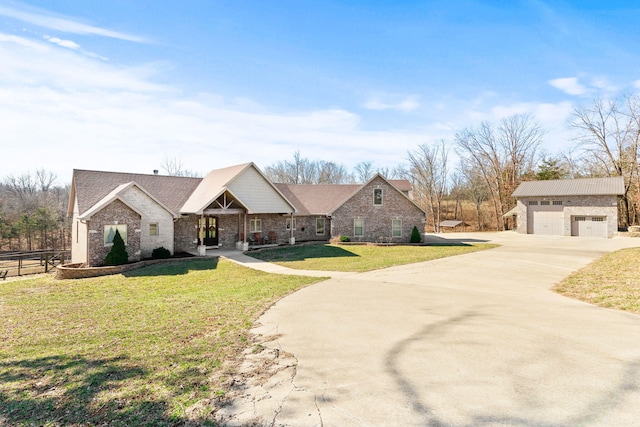 view of front of home featuring a front yard, fence, a garage, and an outbuilding