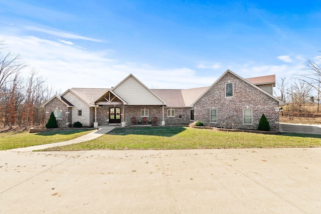 view of front facade with brick siding and a front yard