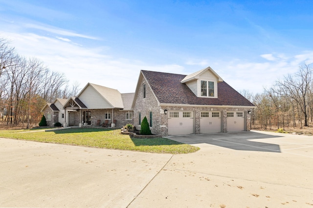 view of front of house with driveway, roof with shingles, a front yard, a garage, and brick siding